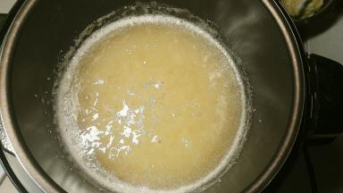 启动电压力锅，不管是煮饭键还是炖汤键，只要能让压力锅加热就可以了，熬到糖冒泡就可以把挤干水份的柚子皮放进去了，糖还没完全融化的话，没关系，柚子皮放进去翻炒一会它自然会化的