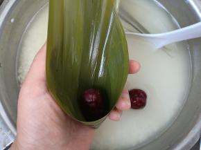 粽叶折成一个漏斗的形状，放进一颗大枣。