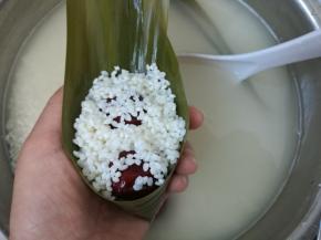 再盖上一层糯米。不能太多，煮的时候后会溢出来，也不能太少，太少的话粽子煮出来不抱团，会散影响口感。