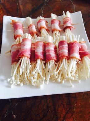 金针菇切掉尾部，培根从中间一切为二。用培根将金针菇卷起，用牙签固定