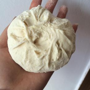 剂子揉圆，按扁，用擀面杖把边上擀薄一些，包上馅料，包成包子。