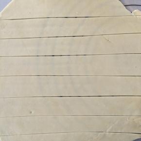 和好的面团，擀成薄片，再用刀划成宽度约为2cm的长条。