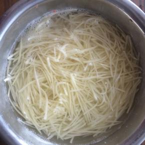 用水淘洗3次土豆丝，洗去土豆丝表面的淀粉。