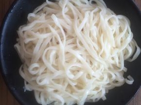 捞出面条、沥干水分，放入碗中。
