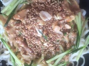 将黄瓜丝、花生碎、熟芝麻放在面条上，淋上稀释好的芝麻酱。