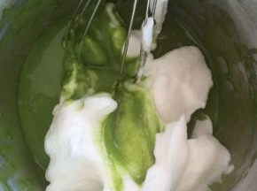 取三分之一的蛋白，放进蛋黄糊中翻拌均匀。不要转圈搅拌，以免消泡。
