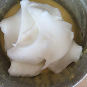 将三分之一打发好的蛋白加到蛋黄糊中，翻拌均匀后倒入剩余的蛋白中，翻拌均匀。