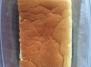 蛋糕卷晾凉后，切成同盒子大小一样的蛋糕片。取一片放入盒子底部。