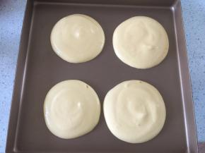 将混合均匀的蛋糕糊装入裱花袋中在烤盘上挤出圆形，