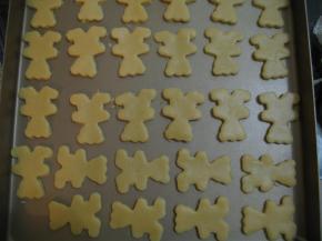 用小熊模具压出饼干形状，小心地将边的面片取出来，再用刮板将小熊 取出，移至烤盘