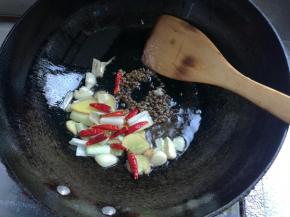 锅坐火上，热锅凉油，下姜片，葱段，蒜瓣炒香，下入干辣椒、麻椒煸炒出香味。