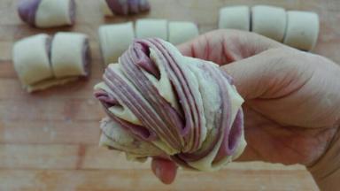 自上而下卷起来，切成均等剂子，两两摞在一起，借助筷子从中间深压一下，两手相反方向扭转，捏好收口