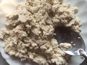 豆腐用勺子碾碎。