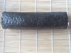提起寿司帘的一端，慢慢卷起，边卷边压紧。