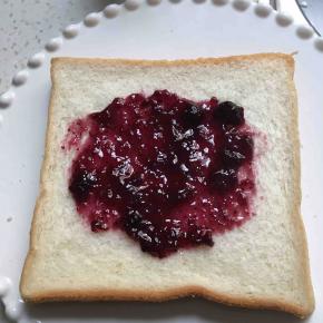 在面包中间涂上蓝莓酱