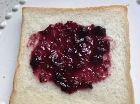 在面包中间涂上蓝莓酱
