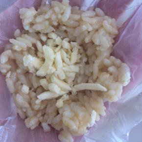 借助保鲜膜，一勺米饭中，包入适量芝士碎。