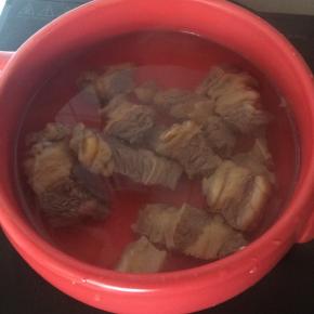 砂锅中放入适量水，焯烫好的牛肉、葱段、姜片。