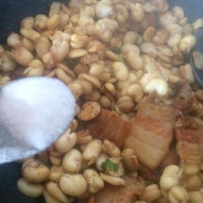 放入蚕豆瓣翻炒。
撒适量盐。