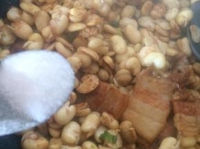 放入蚕豆瓣翻炒。
撒适量盐。