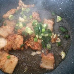 锅内放入适量食用油，先煸炒五花肉片，加入老抽调色。
放入葱花。