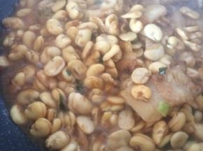 加入适量水，没过蚕豆的一半，盖锅盖焖煮3分钟，豆瓣微微开裂即可。