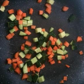 锅内倒入适量食用油，放入黄瓜丁、胡萝卜丁翻炒片刻。