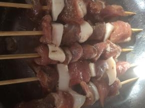竹签提前用水浸泡一会儿，把腌好的羊肉用竹签肥瘦相间的串起来。