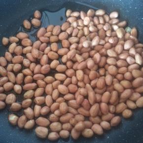 锅内倒入适量食用油，放入花生米，小火慢炒。