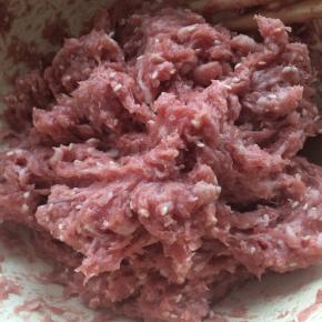 加入盐、蚝油、胡椒粉、糖、红曲粉、玉米淀粉，用筷子顺着一个方向搅拌。
搅拌至猪肉上劲即可。