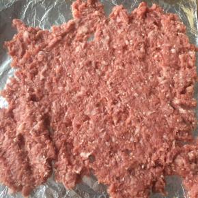 烤盘铺锡纸，刷一层油，放入一半的猪肉馅。