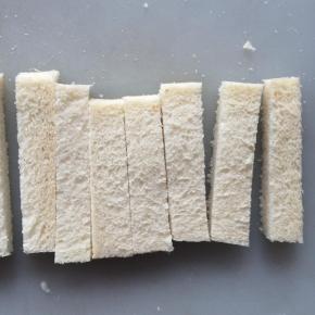 吐司切去四边。
切成1cm宽的细条。