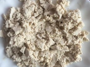 豆腐用勺子碾碎。