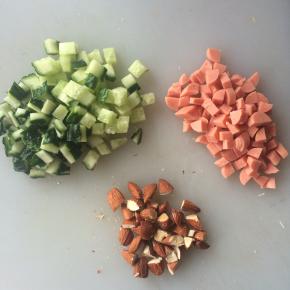 黄瓜切小丁、火腿肠切小丁、巴旦木用刀拍碎。
