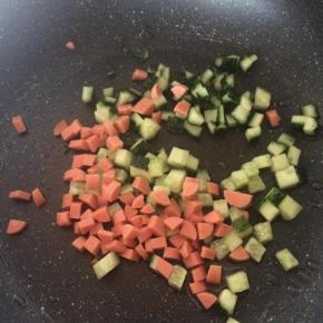 锅内倒入适量食用油，先放入黄瓜丁、火腿丁翻炒。