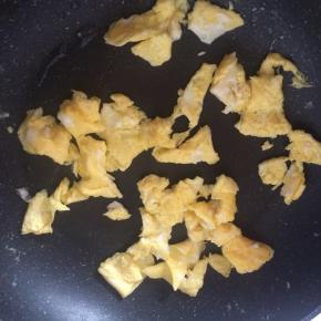 锅内倒入适量食用油，油温7成热时倒入鸡蛋液，边炒边划散鸡蛋。炒好的鸡蛋盛出备用。