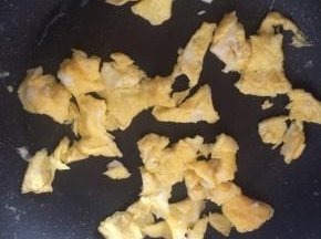 锅内倒入适量食用油，油温7成热时倒入鸡蛋液，边炒边划散鸡蛋。炒好的鸡蛋盛出备用。