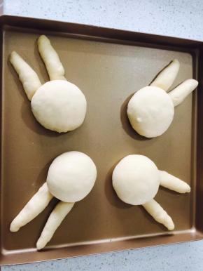 把面团放在提前做好的兔子耳朵上，放在温暖处发酵