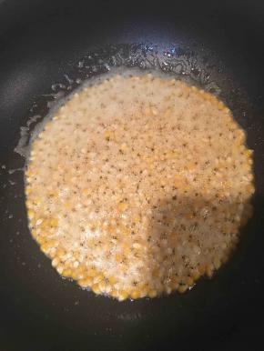 倒入玉米粒，小火，晃动锅子，让每粒玉米都沾上油