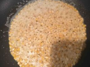 倒入玉米粒，小火，晃动锅子，让每粒玉米都沾上油