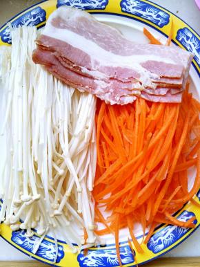 准备好食材将洗干净的金针菇、红萝卜.培根装盘子中，