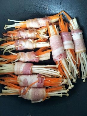 、不粘锅烧热后，将卷好的培根摆放上去