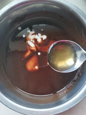 将桂花酒和鲜奶加入融化的巧克力酱中。