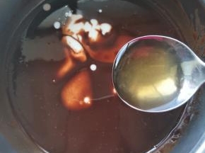 将桂花酒和鲜奶加入融化的巧克力酱中。