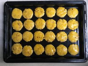 圆团压成饼，均匀地摆放在烤盘里，刷上蛋液。