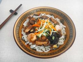 先盛上半碗热气腾腾的面，浇上一小碗三鲜卤，再撒上些菜码，拌一拌，就着蒜瓣吃，真的很香。