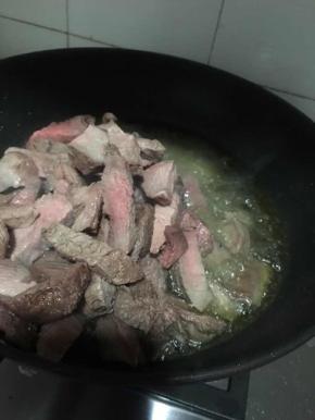 油烧热后倒入牛肉条中小火翻炒一会儿加入盐继续翻炒。