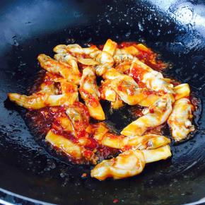 迅速翻炒均匀，让酱料裹住海蛏子肉，这时滴入几滴香油。