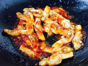 迅速翻炒均匀，让酱料裹住海蛏子肉，这时滴入几滴香油。