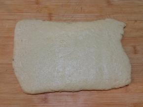 桌上撒薄面，面团擀开，折叠几下，压成2厘米厚
